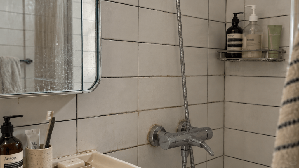 Old rental bathroom tile with visible buildup and worn grout