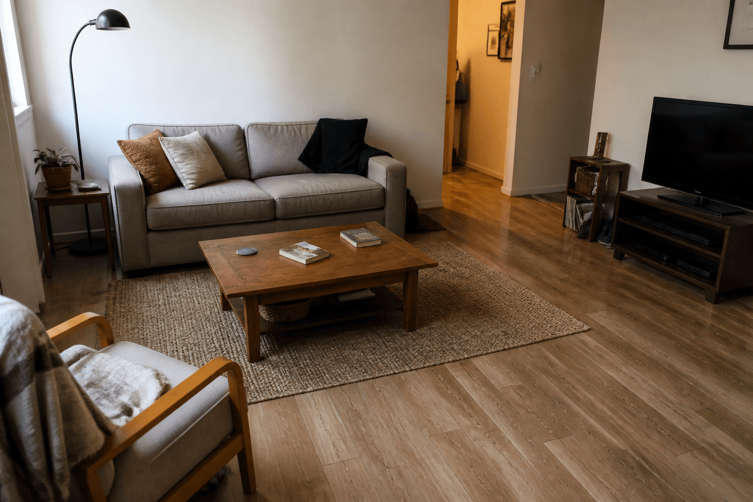 Rental living room with dated flooring and an area rug
