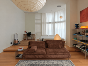 Original photograph of a rental apartment illuminated by several warm light sources around the living and sleeping areas.